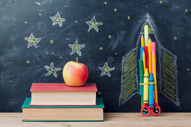 back-to-school-concept-rocket-made-pencils-books-over-chalkboard-background-96573196